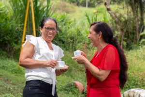 Two Latine woman laughing and enjoying coffee
