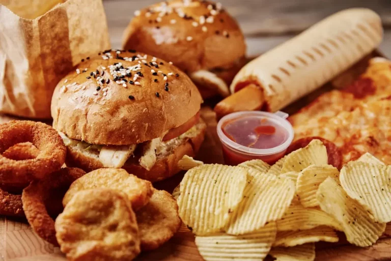 Assortment of ultra-processed fast foods including chips, burgers, and fried snacks