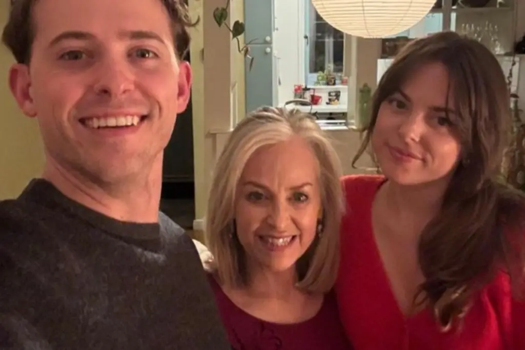 Lynn Swanson posing with her adult children during a family gathering at home.