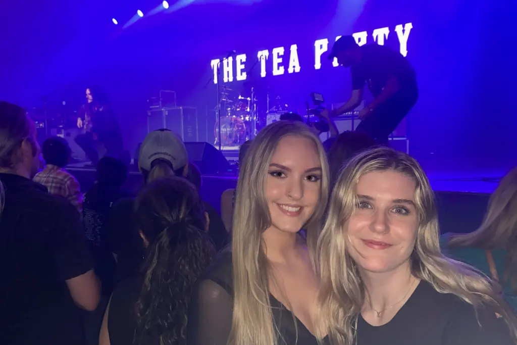 MacKenzie MacDougall attending a live concert with a friend in front of the stage.