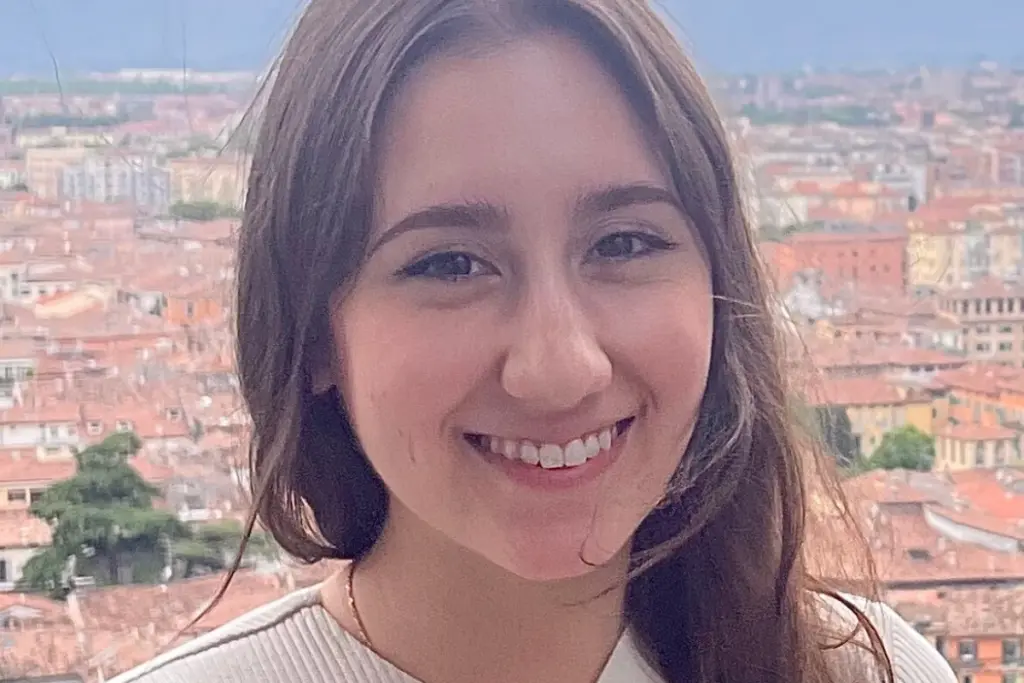 Rebecca Haywood smiling with a cityscape view in the background.