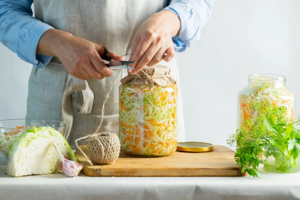 Preparing homemade fermented vegetables in glass jars to support gut health and overall wellbeing