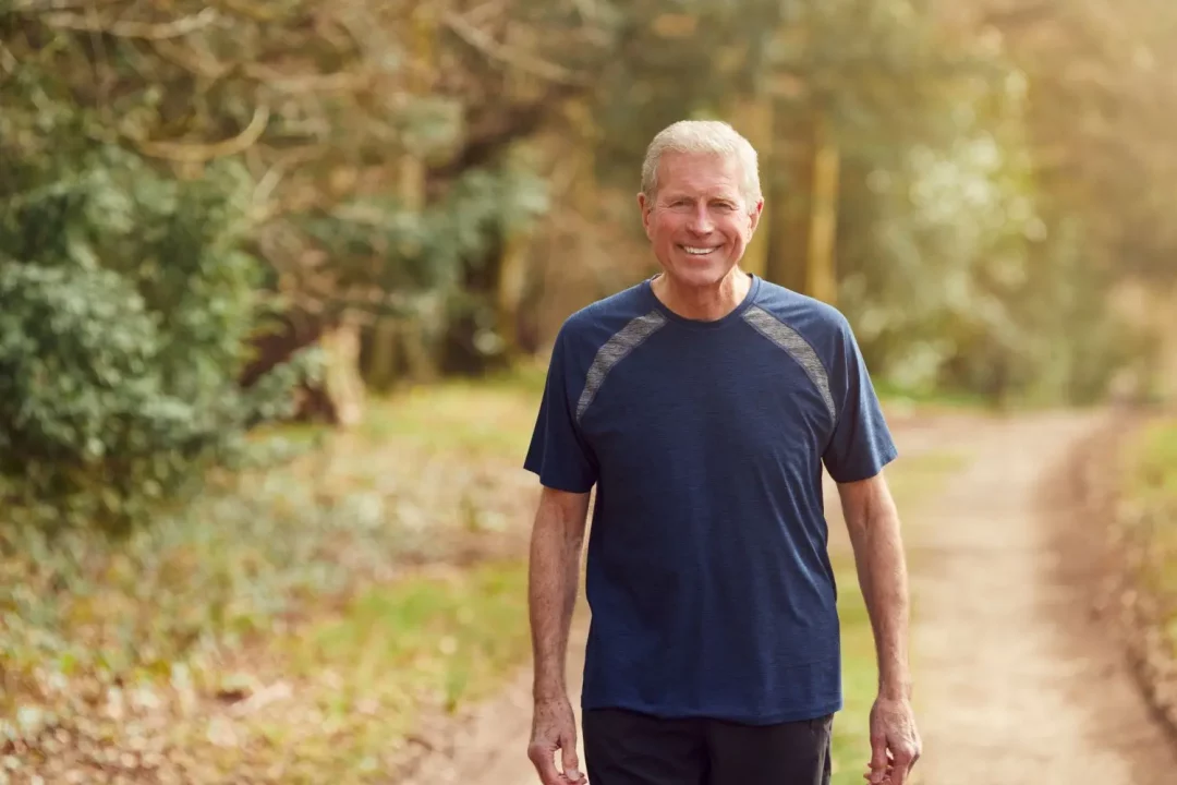 Older man walking outdoors, active aging, and longevity